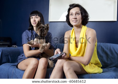 domestic life: 2 girls in dress and dog watching a comedy movie