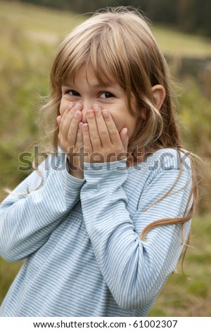 Portrait of a cute little girl nine years old closing to her mouse by her hands