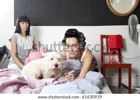 friends with dog watch TV sitting on bed