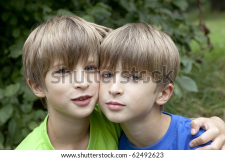 Two smiling twin brothers outdoor portrait