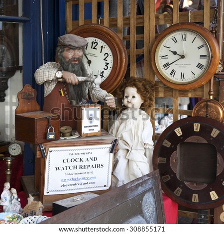 LONDON - AUG 16:  Clock and watch repair near vintage shop at Portobello Market, in Notting Hill district, largest antiques market in UK, famous tourist attractions, on AUG 16, 2015, London, UK.