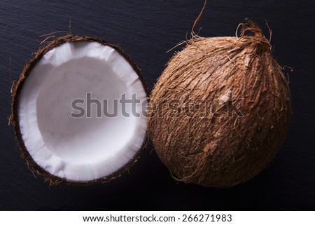Coconut whole and halved shot from above. Close-up and shot on a black background.