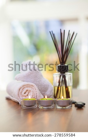 towels, candles, hot stones and scent sticks on wooden background shot front on
