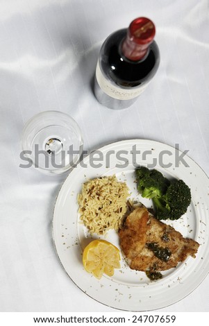 fish meal with selective focus and wine botle and glass in the background