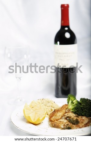 fish meal with selective focus and wine botle and glass in the background