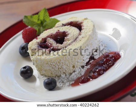 sweet swiss cake on a plate with fruit and jam. Shallow depth of field.