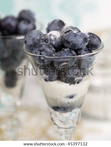 blueberry fruit in glass with sugar and cream. Shallow depth of field.