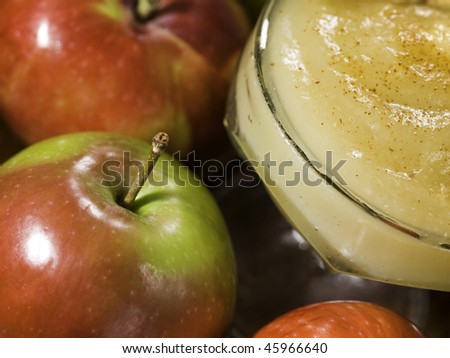 apple sauce dessert (stewed apple) with whole apples around. Shallow depth of field.