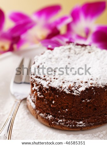 molten chocolate cake with orchid flower in the background. Very shallow depth of field.