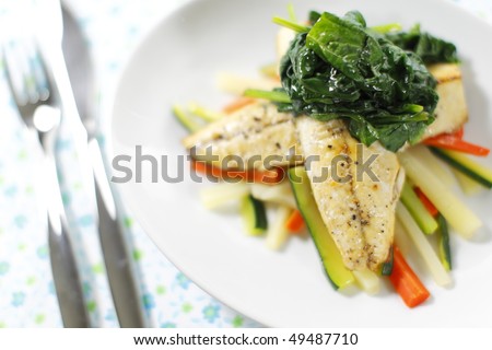 cooked mackerel fish meal with spinach on the top. Carrot and zukini below. Very shallow depth of field.