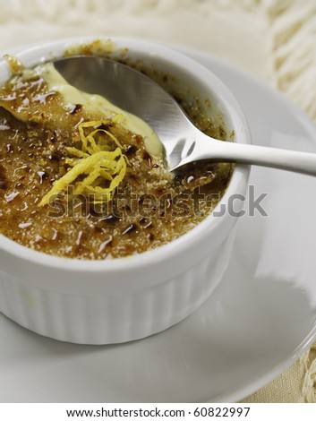 creme brulee desert on white plate with a spoon. French culture cuisine.