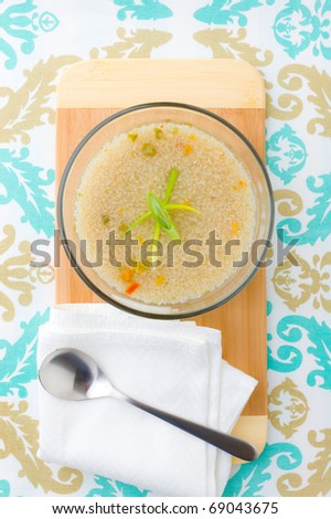 Bio quinoa soup in a bowl with wooden plate. Shallow depth of field.