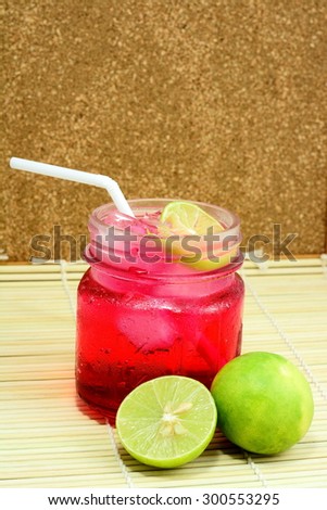 Red cocktail with lemon slice isolated on bamboo pad plate