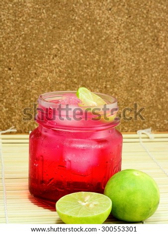Red cocktail with lemon slice isolated on bamboo pad plate