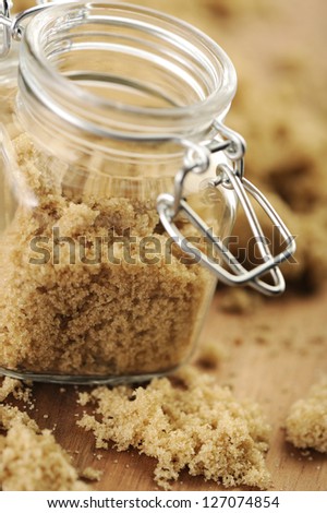 Raw brown sugar in a small jar.