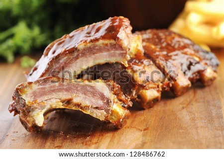 Grilled sliced barbecue pork ribs on a wooden background.
