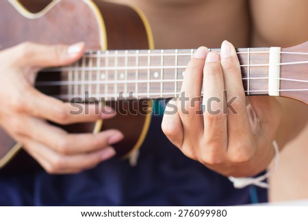close up  playing ukulele   , string instrument , body part  , body part