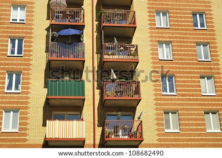 Balconies on the side of a building with many windows.