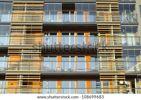 Balconies on the side of a building with many windows.