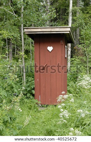 Rustic outhouse building in a wooded area.
