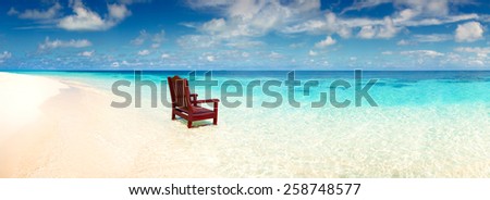 Wooden chair standing in the sea on the beach invitation to rest on a deserted island alone, a wide panoramic view of the ocean