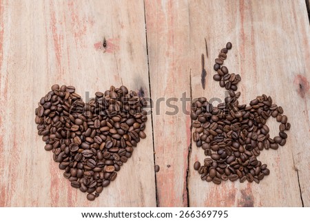 cup of coffee and coffee beans heart on table