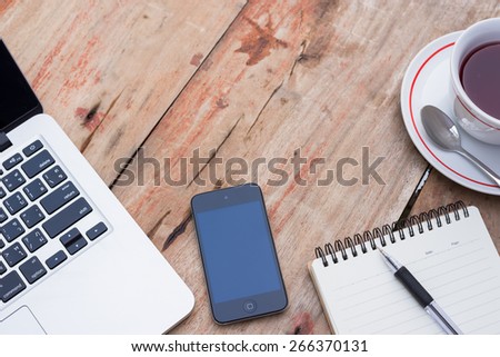 mobile phone laptop  notebook and cup of coffee on table