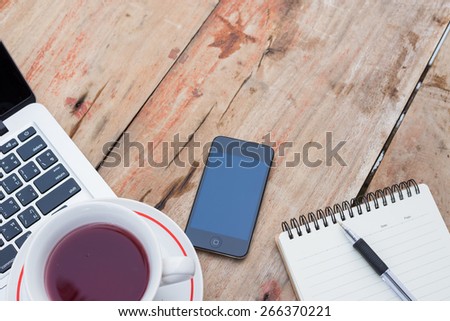 mobile phone laptop  notebook and cup of coffee on table