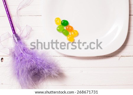 feathers and caramel on the plate on white wooden table