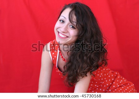 Beautiful young smiling  business woman wearing red dress on red  background