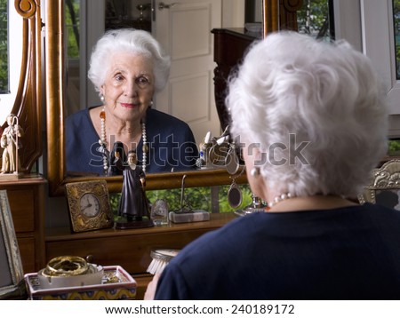 Portrait of an elderly woman looking in the mirror