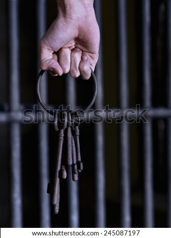 Male hand holding giant old keys on a key ring
