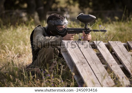 Protective sport player in uniform and mask Aiming gun