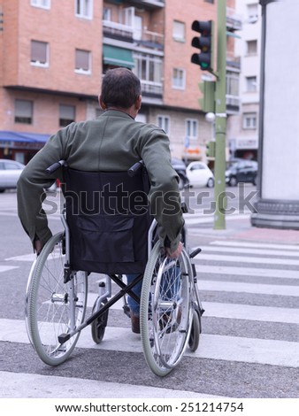 Man in wheelchair crossing a zebra