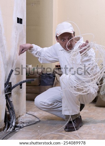 Worker with a cable. Electrician, staring a cable guide