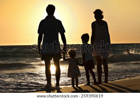 Family walking on the beach in sunset