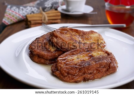 French toast on a plate, and bottom cinnamon, honey and a cup of coffee