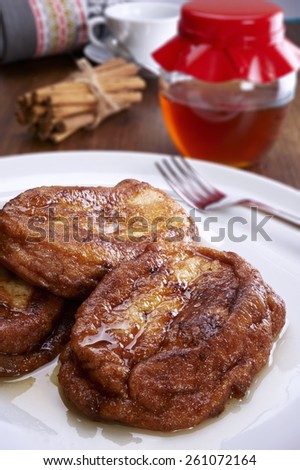 French toast on a plate, and bottom cinnamon, honey and coffee
