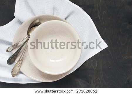 Empty plates and spoons on the wooden table with napkin