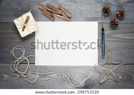 Blank sheet of paper with composition on the dark wooden textured table