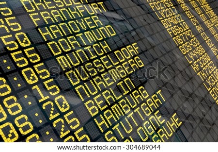Close-up of an airport departure board to german cities destinations, with environment reflection.Part of a series.