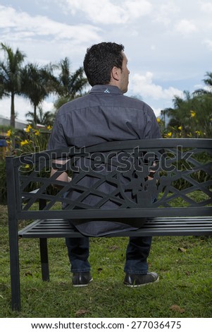 Man sitting on chair back looking at the landscape park