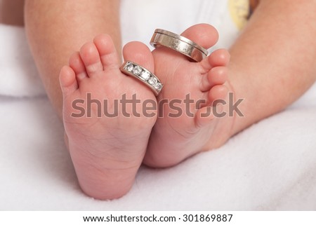Baby feet with wedding rings parents