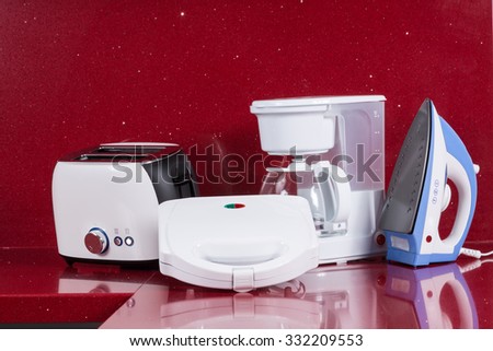 Household appliances in modern kitchen red background
