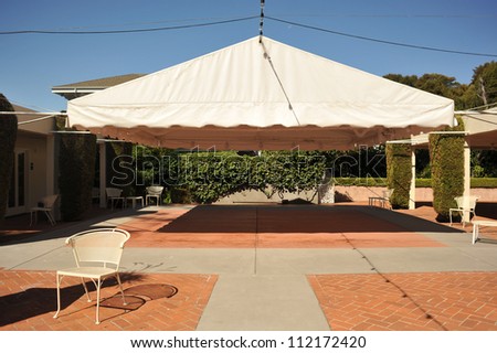 Chair next to an open area covered by a white canopy.