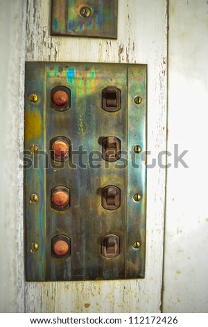 Switches and lights on an old brass control panel
