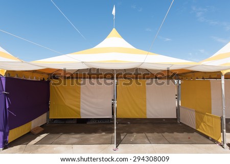 Canopy tent set up outdoors with flag on top is empty