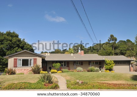 Brown single family house with grass in front has wires and cables coming off the roof