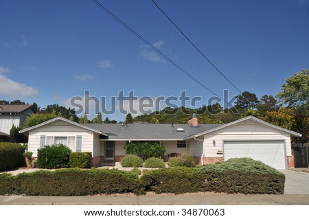 White single family house with grass in front has wires and cables coming off the roof