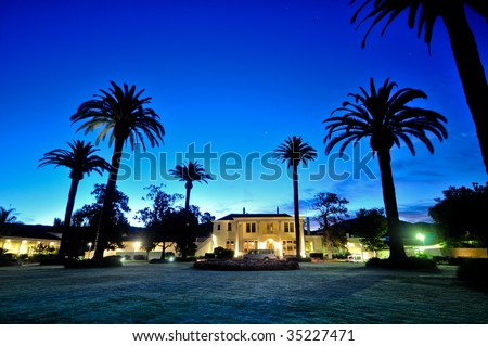 Majestic building with palm trees and grass